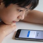 adolescente penchee sur smartphone affichant ecran de recuperation