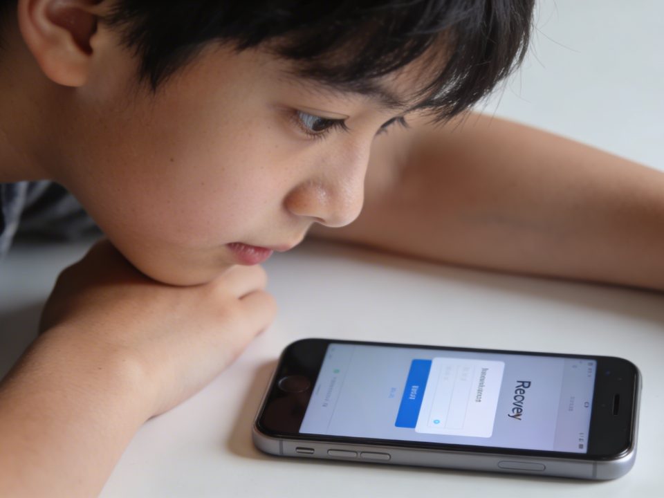 adolescente penchee sur smartphone affichant ecran de recuperation