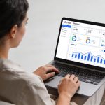 Femme assise devant ordinateur affichant tableau de bord Google