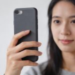 jeune femme tenant smartphone vertical devant visage