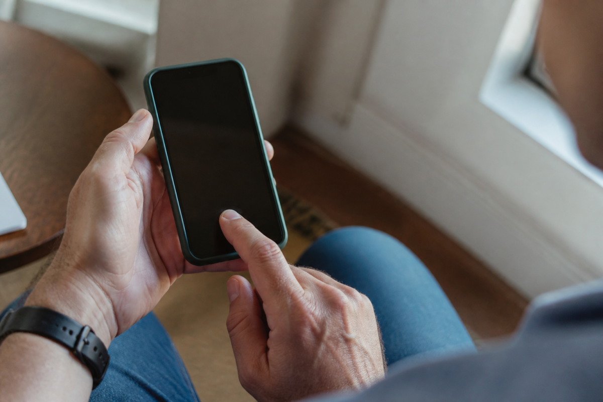 Main posant un doigt sur ecran smartphone pour authentification