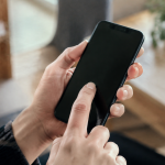 Mains touchant ecran tactile smartphone noir vertical