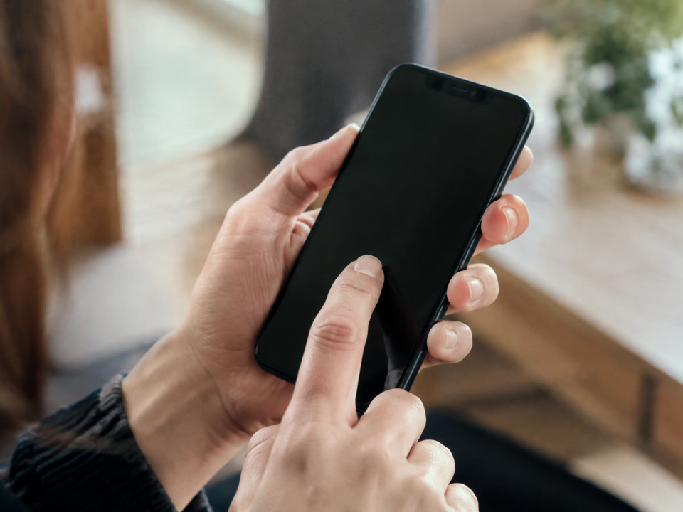 Mains touchant ecran tactile smartphone noir vertical