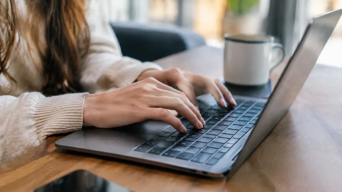 Mains pressant les touches sur un ordinateur portable
