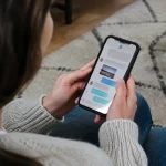 Main tenant un smartphone affichant une conversation de messages